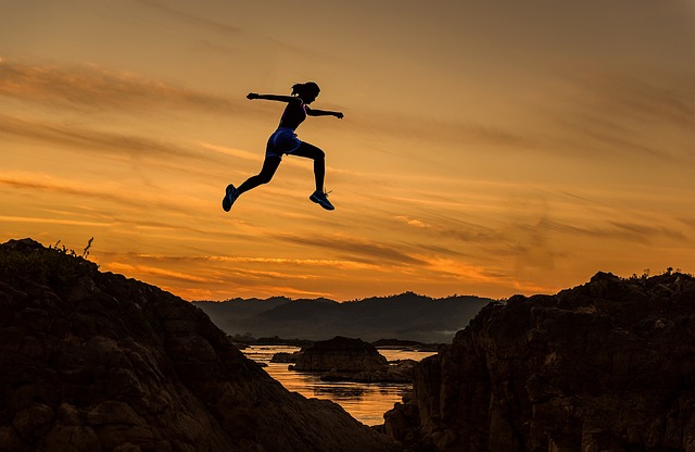 Runner jumping in the air at sunset