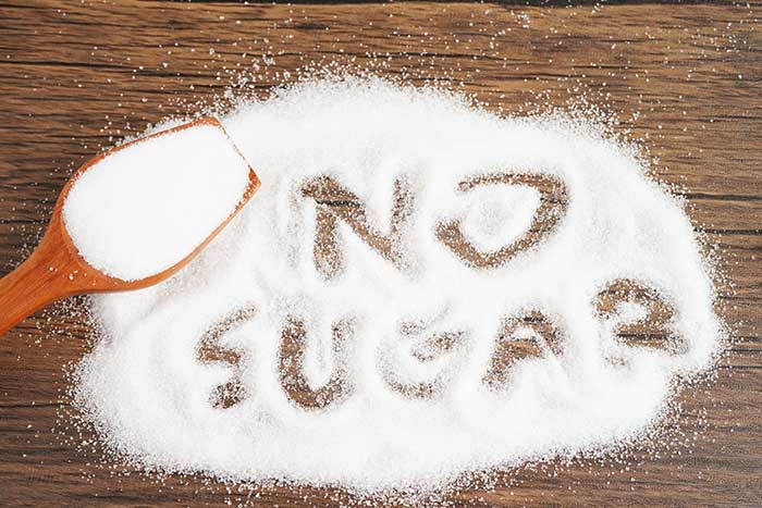 A pile of sugar with "No Sugar" written in it, indicating how the chocolate is sugar free
